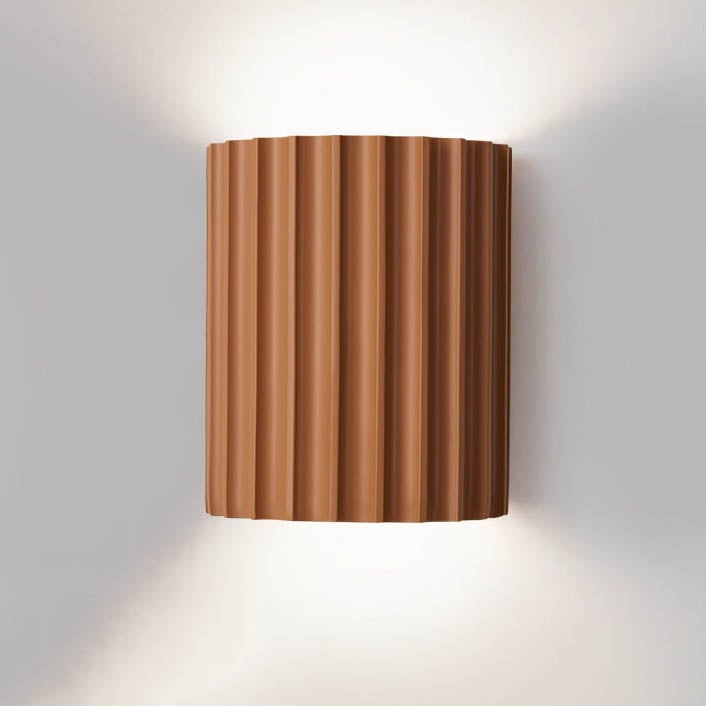 Wall-mounted light fixture with a ribbed brown design on a white wall.