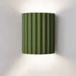 Green wall-mounted lamp with ribbed design on a white background