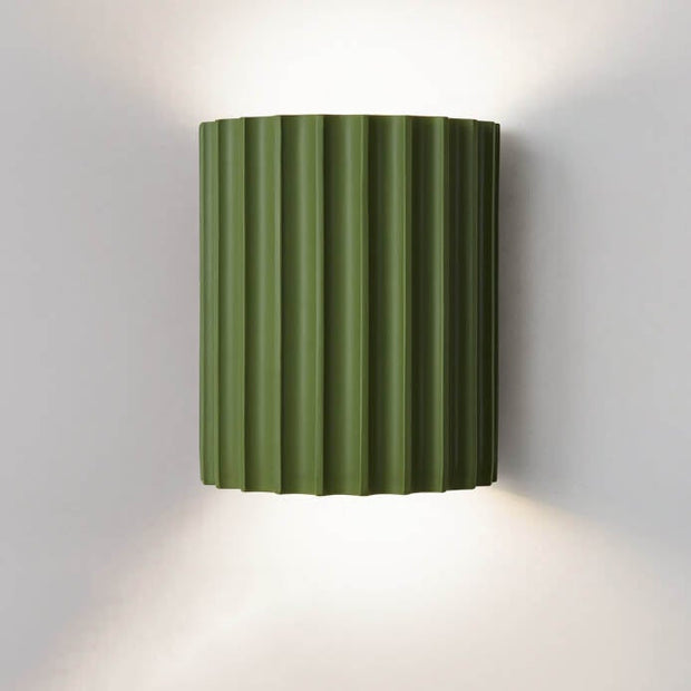 Green wall-mounted lamp with ribbed design on a white background