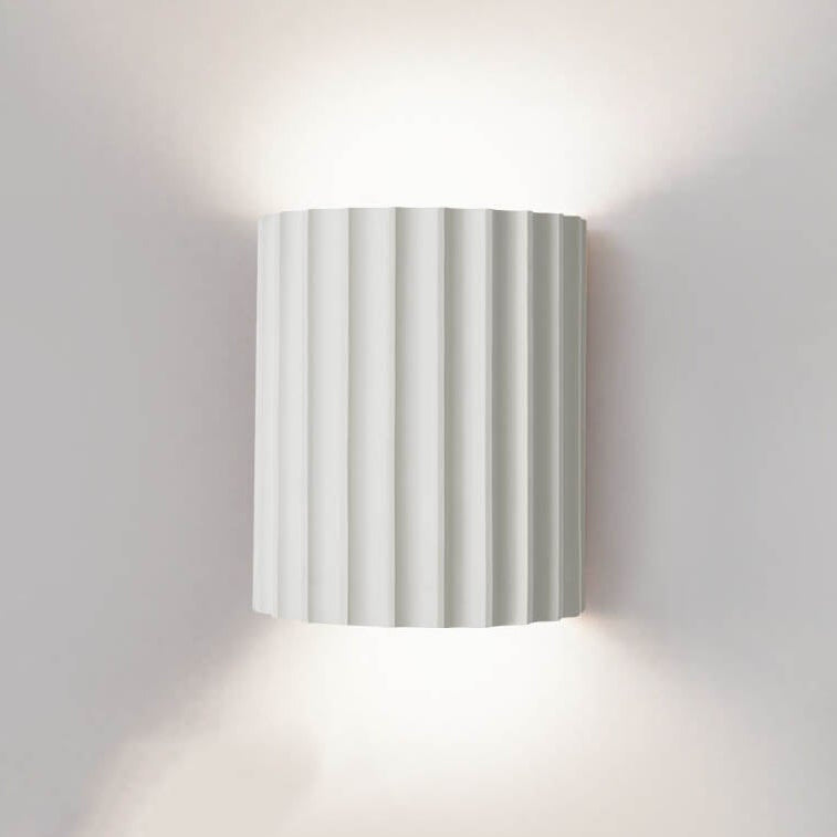 Wall-mounted lamp with striped design on a plain wall