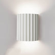 Wall-mounted lamp with striped design on a plain wall
