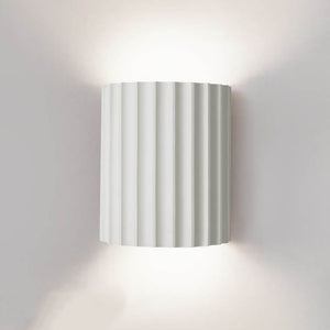 Wall-mounted lamp with striped design on a plain wall