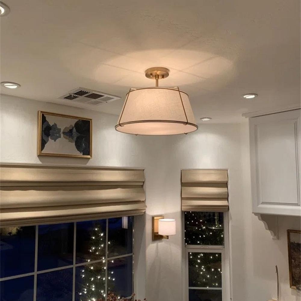Ceiling light fixture in a room with a window view of lights outside