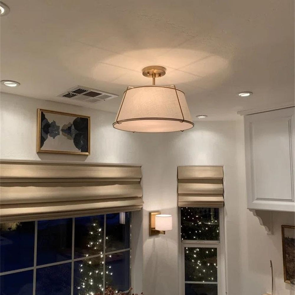 Ceiling light fixture in a room with a window view of lights outside