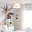 Modern bedroom with surfboard, palm tree decor, and ceiling light fixture.