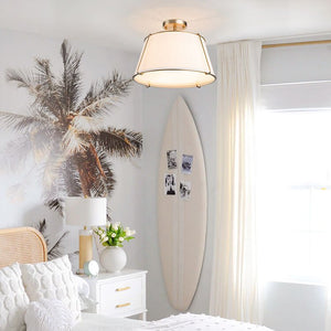 Modern bedroom with surfboard, palm tree decor, and ceiling light fixture.