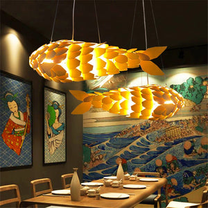 Modern yellow pendant lights hanging above a dining table with artistic wall decorations.